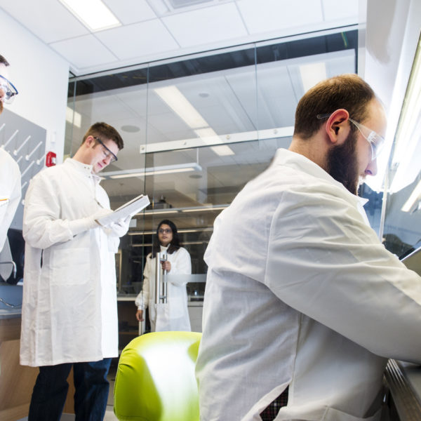 三个男生在罩在一个实验室工作。