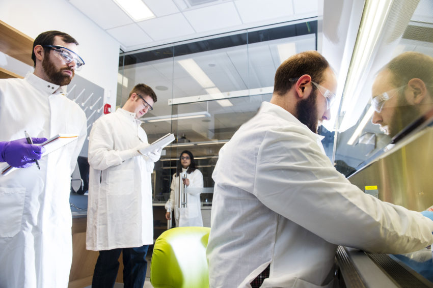 三个男生在罩在一个实验室工作。
