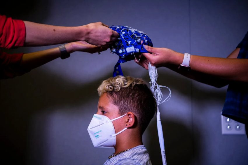 9岁的普赖斯在接受认知与大脑健康中心的测试之前，戴上了一顶感觉帽