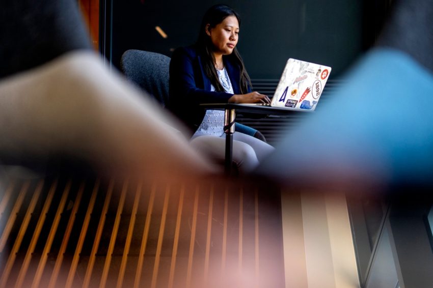 索菲亚·Ly坐在笔记本电脑前工作