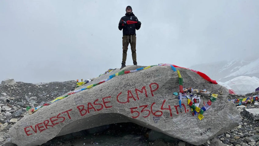 亚历山大·安德森站在珠峰大本营的岩石上