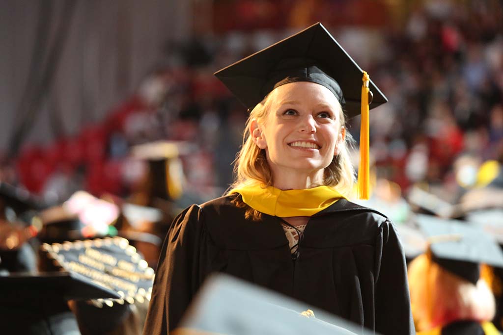 2022年5月在马修斯竞技场举行的CPS毕业典礼上，一名女CPS毕业生微笑着抬头。摄影:Heratch Ekmekijan