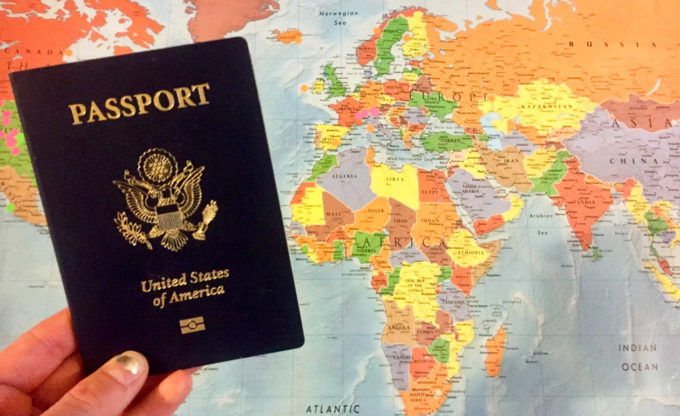 美国护照放在世界地图前面。