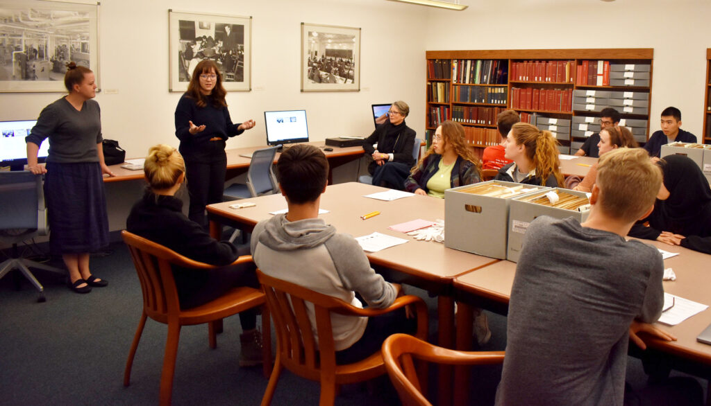Regina Pagani和Molly Brown在档案阅览室教一个班级的学生