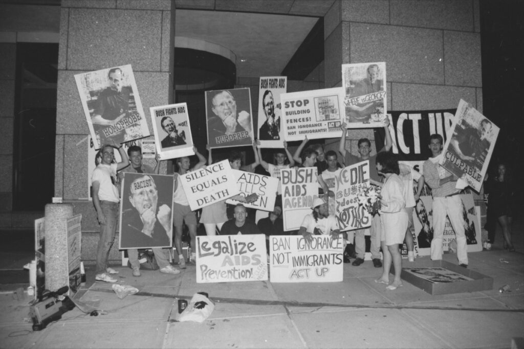 一群抗议者举着批评乔治·HW·布什的标语，要求预防艾滋病和获得资源。