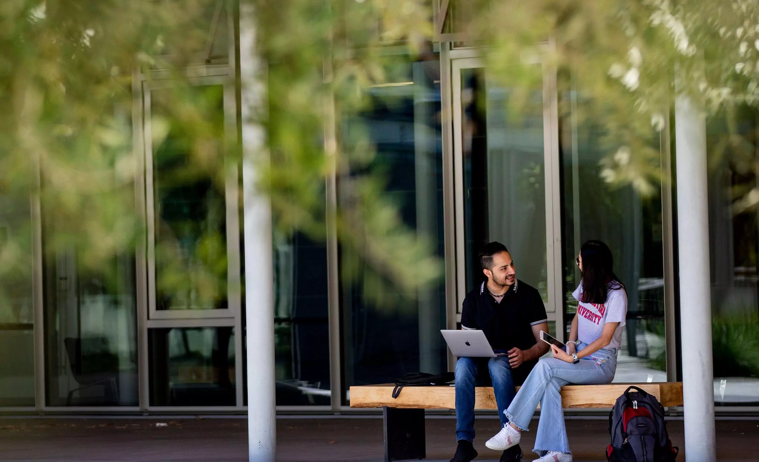 学生们坐在东北大学奥克兰校区劳里I.洛基商业与公共政策研究生院外的长椅上raybet雷竞技雷竞技app最新版