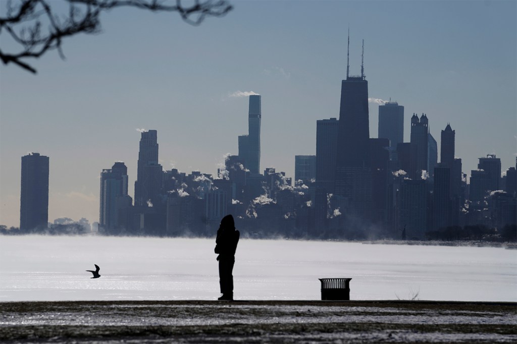 Silhouette 一个女人站起 冷在芝加哥密歇根湖前