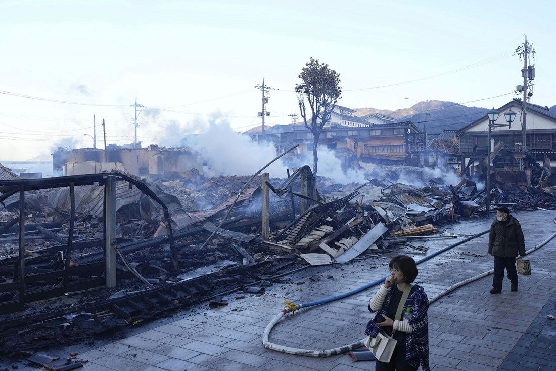 人民在日本地震后走过燃烧市场