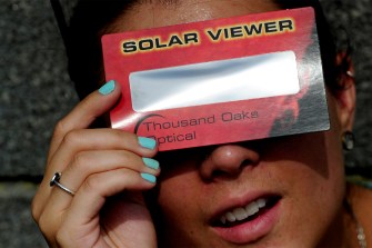 人使用太阳能查看器看日食