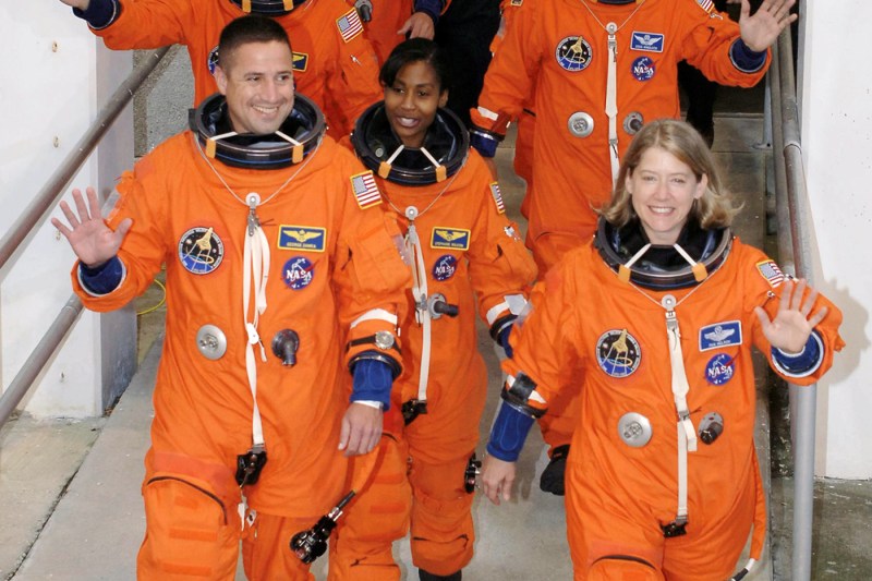 Pam Melroy和另外两人穿橙色太空服