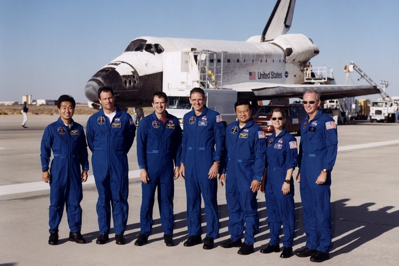 七位乘员站在跑道上航天飞机外