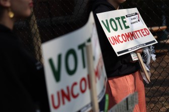 密歇根州投票站外 持有Vote匿名标志