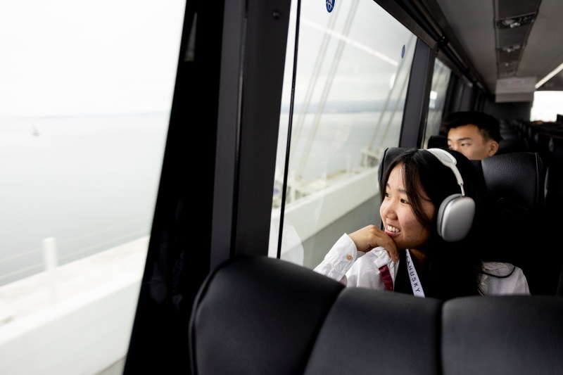 身穿银耳机的人坐公交车时向窗外望云