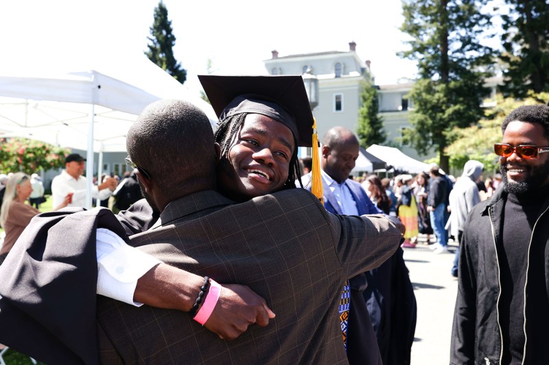 毕业生从另一个人那里得到拥抱