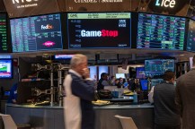 商人在纽约证券交易所前行屏幕显示GameStop标识