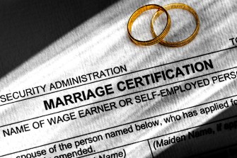 一张结婚证书表格上叠着两个金环