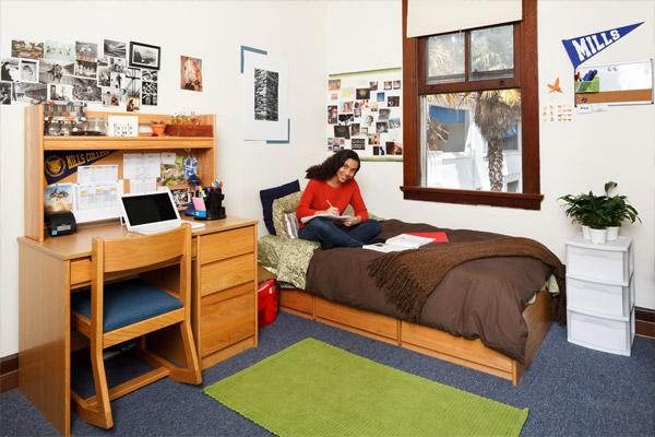 一名学生坐在Orchard Meadows宿舍的床上看书