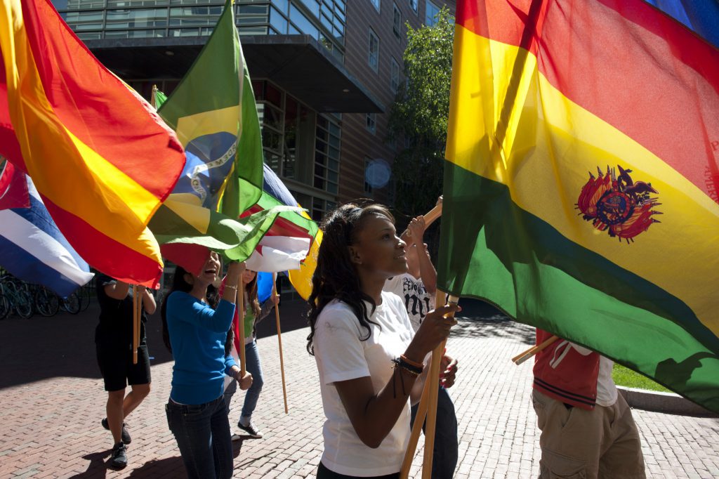 学生在外面散步,带着各种不同的国家的旗帜